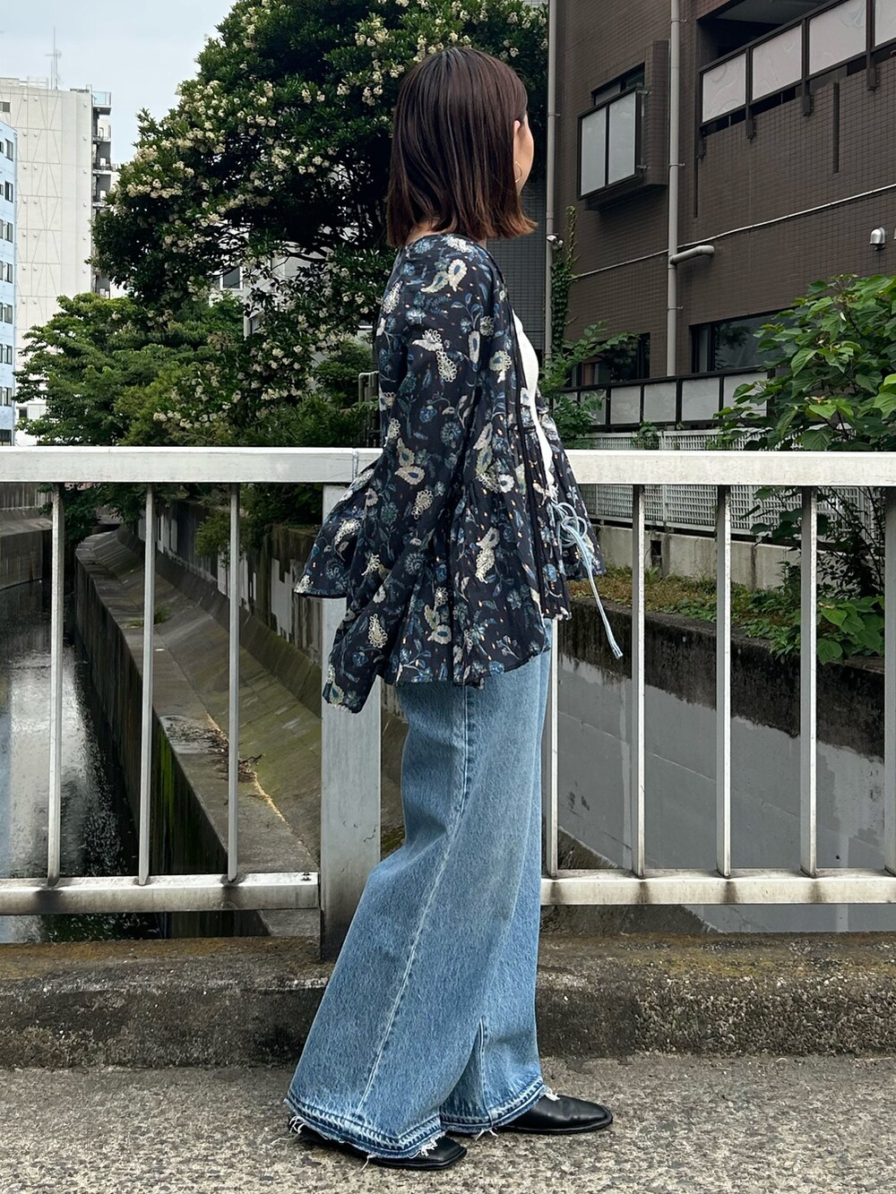 ブルー系のデニムパンツ、ブルー系のシャツ/ブラウス、ホワイト系のTシャツ/カットソーを着用したレディースの夏コーディネートの3枚目の写真