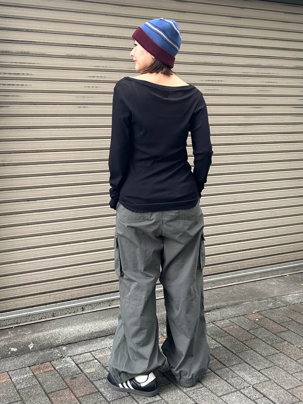 ブラック系のTシャツ/カットソー、ベージュ系のカーゴパンツ、レッド系のニットキャップ/ビーニーを着用したレディースの秋コーディネートの3枚目の写真