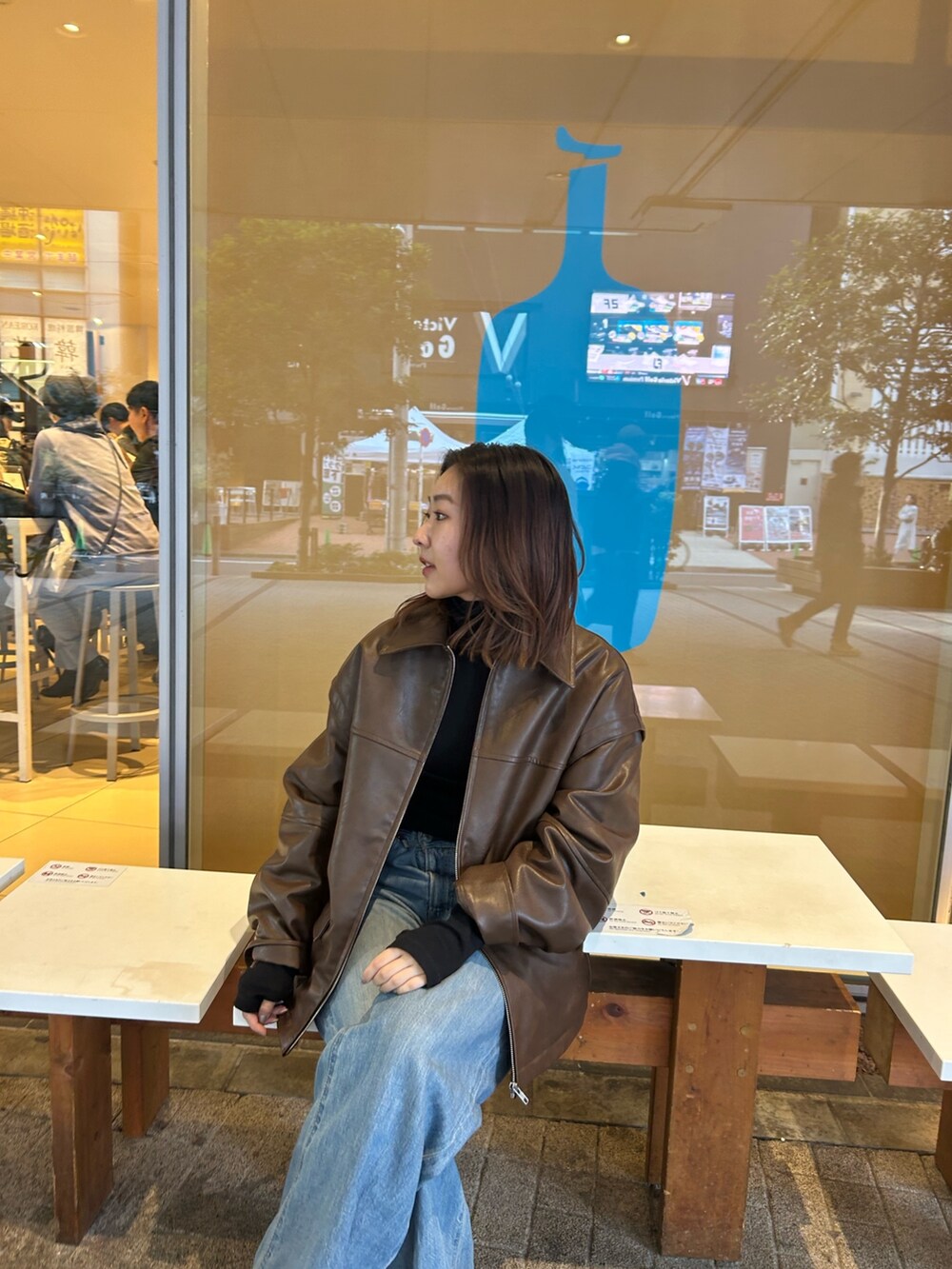 ブラウン系のブルゾン、ブルー系のデニムパンツ、ブラック系のTシャツ/カットソーを着用したレディースの冬コーディネートの3枚目の写真