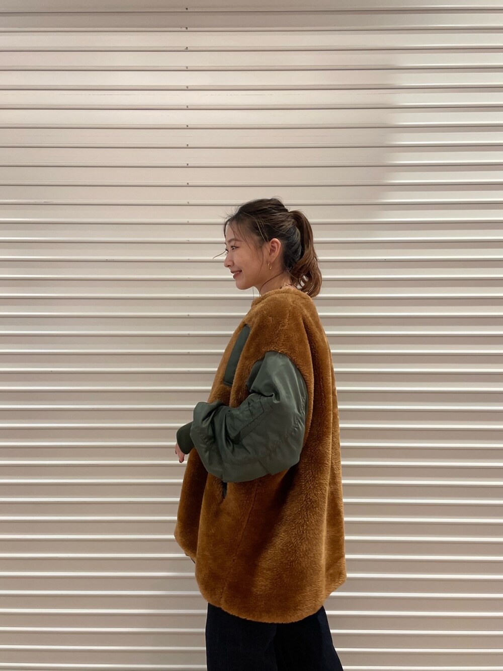 ベージュ系のブルゾン、ブルー系のデニムパンツを着用したレディースの秋コーディネートの2枚目の写真