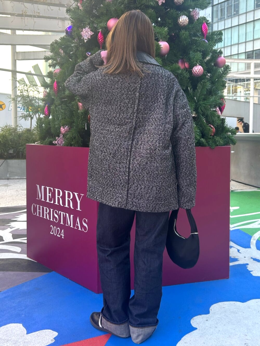 ブラック系のブルゾン、ブルー系のデニムパンツ、ピンク系のニット/セーターを着用したレディースの冬コーディネートの3枚目の写真