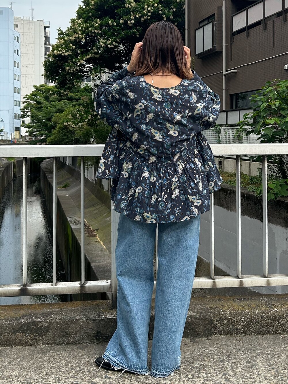 ブルー系のデニムパンツ、ブルー系のシャツ/ブラウス、ホワイト系のTシャツ/カットソーを着用したレディースの夏コーディネートの2枚目の写真