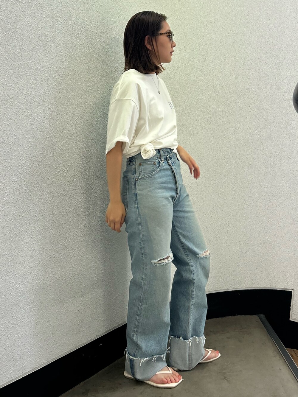 ホワイト系のTシャツ/カットソー、ブルー系のデニムパンツ、ホワイト系のサンダルを着用したレディースの夏コーディネートの2枚目の写真