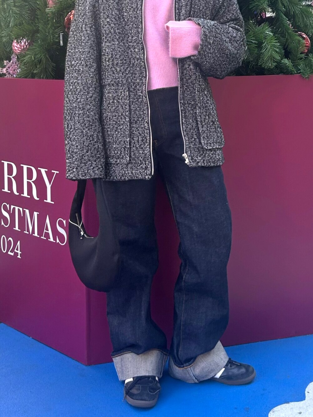 ブラック系のブルゾン、ブルー系のデニムパンツ、ピンク系のニット/セーターを着用したレディースの冬コーディネートの5枚目の写真