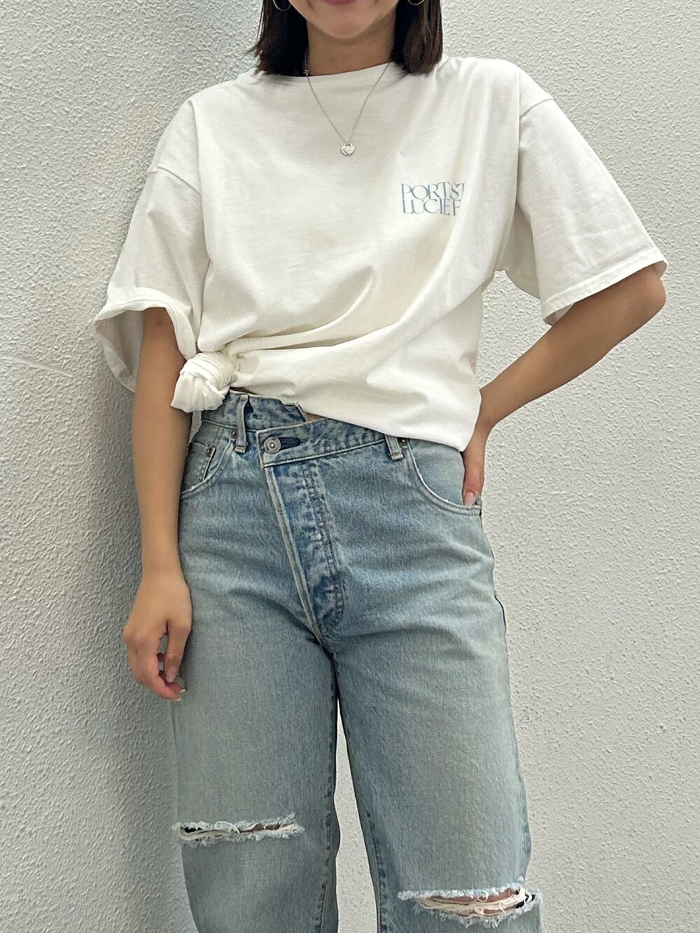 ホワイト系のTシャツ/カットソー、ブルー系のデニムパンツ、ホワイト系のサンダルを着用したレディースの夏コーディネートの4枚目の写真