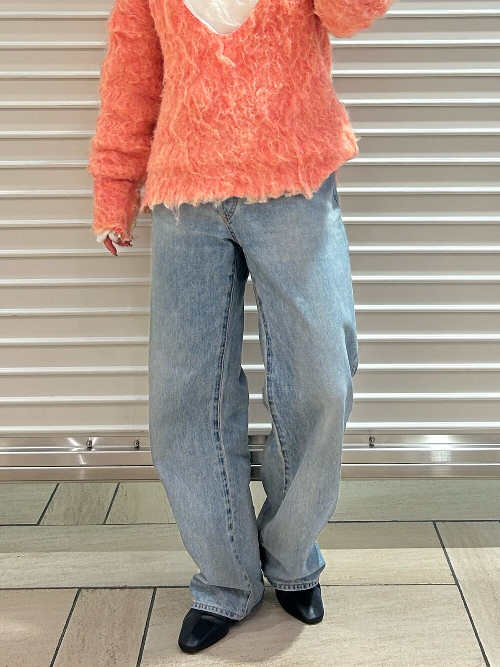 ピンク系のニット/セーター、ブルー系のデニムパンツを着用したレディースの冬コーディネートの5枚目の写真