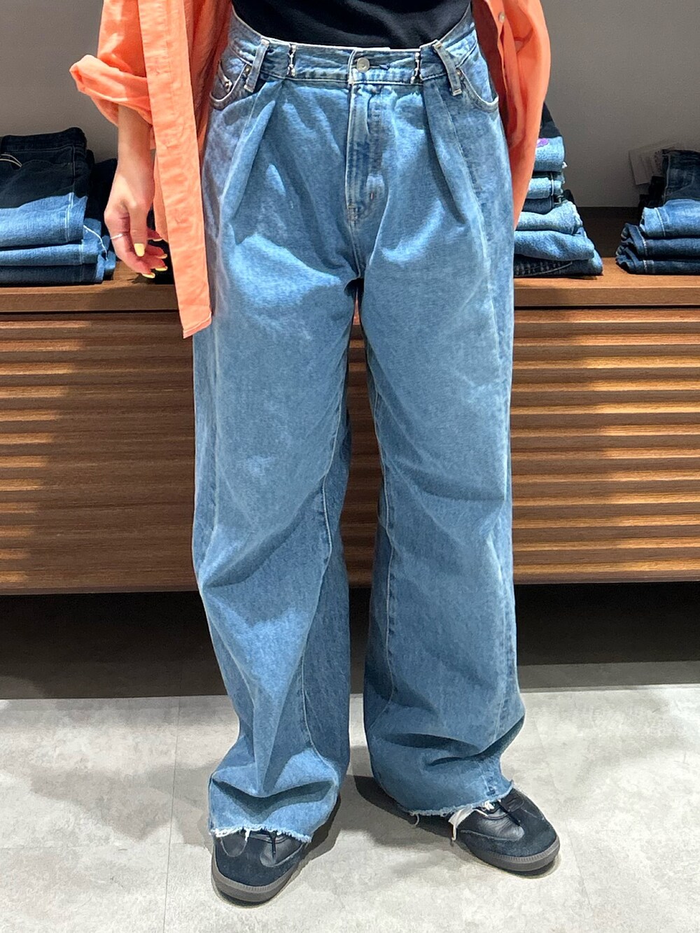 ブルー系のデニムパンツ、ブラック系のキャミソール、オレンジ系のシャツ/ブラウスを着用したレディースの春コーディネートの4枚目の写真