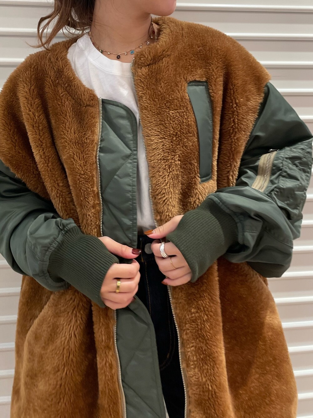 ベージュ系のブルゾン、ブルー系のデニムパンツを着用したレディースの秋コーディネートの4枚目の写真