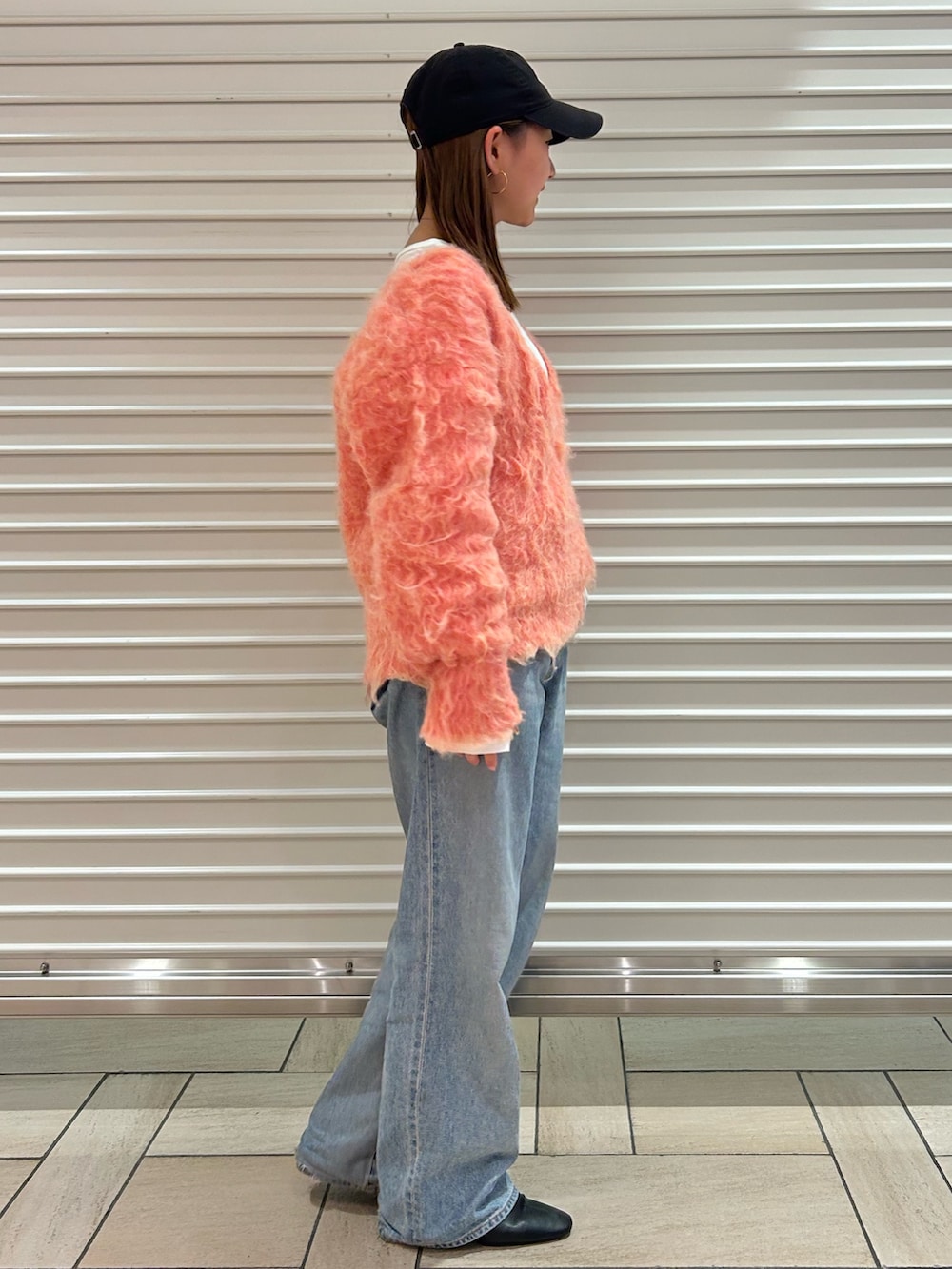 ピンク系のニット/セーター、ブルー系のデニムパンツを着用したレディースの冬コーディネートの2枚目の写真