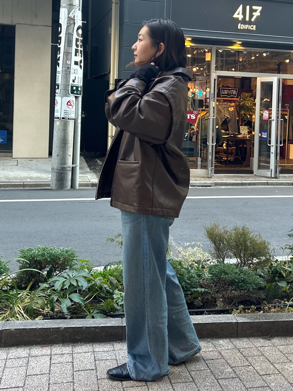 ブラウン系のブルゾン、ブルー系のデニムパンツ、ブラック系のTシャツ/カットソーを着用したレディースの冬コーディネートの2枚目の写真