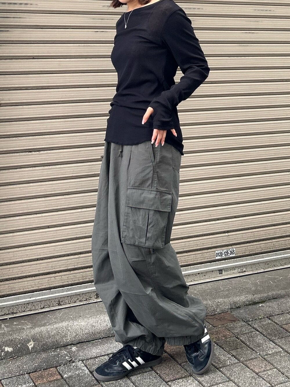 ブラック系のTシャツ/カットソー、ベージュ系のカーゴパンツ、レッド系のニットキャップ/ビーニーを着用したレディースの秋コーディネートの2枚目の写真