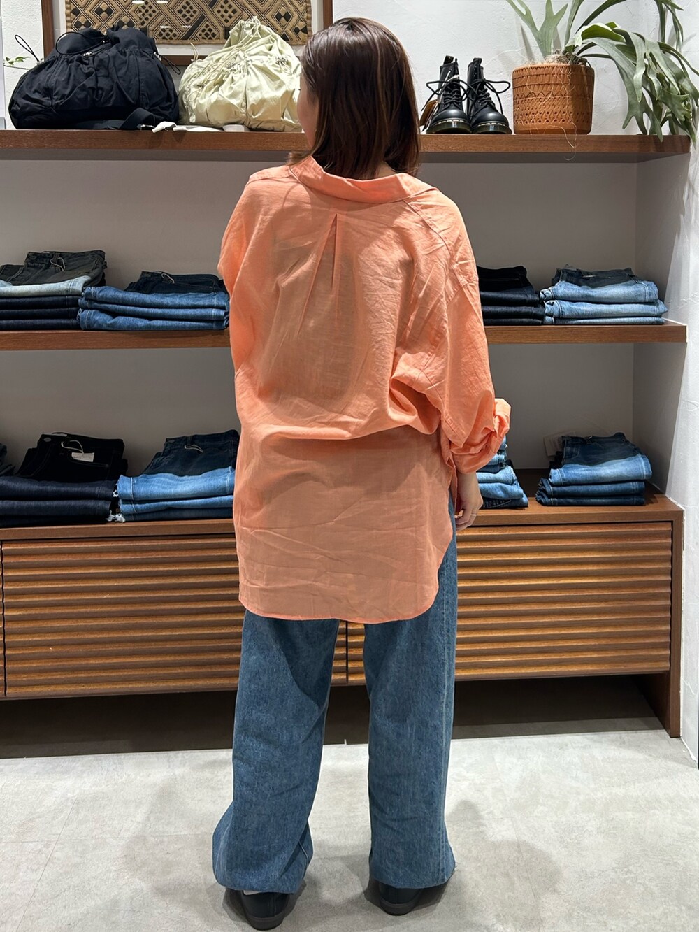 ブルー系のデニムパンツ、ブラック系のキャミソール、オレンジ系のシャツ/ブラウスを着用したレディースの春コーディネートの5枚目の写真