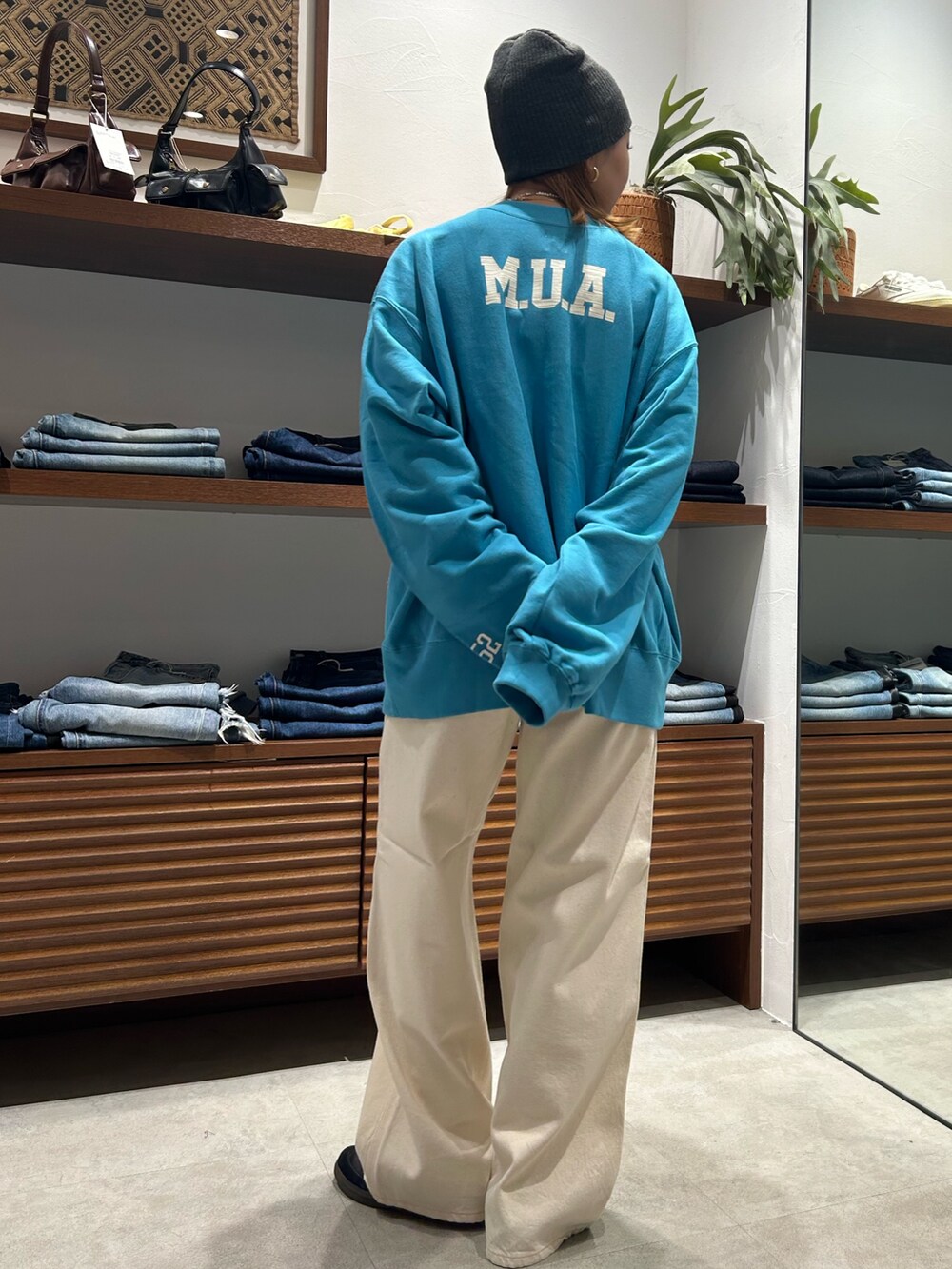 ブルー系のスウェット、ホワイト系のデニムパンツを着用したレディースの冬コーディネートの3枚目の写真