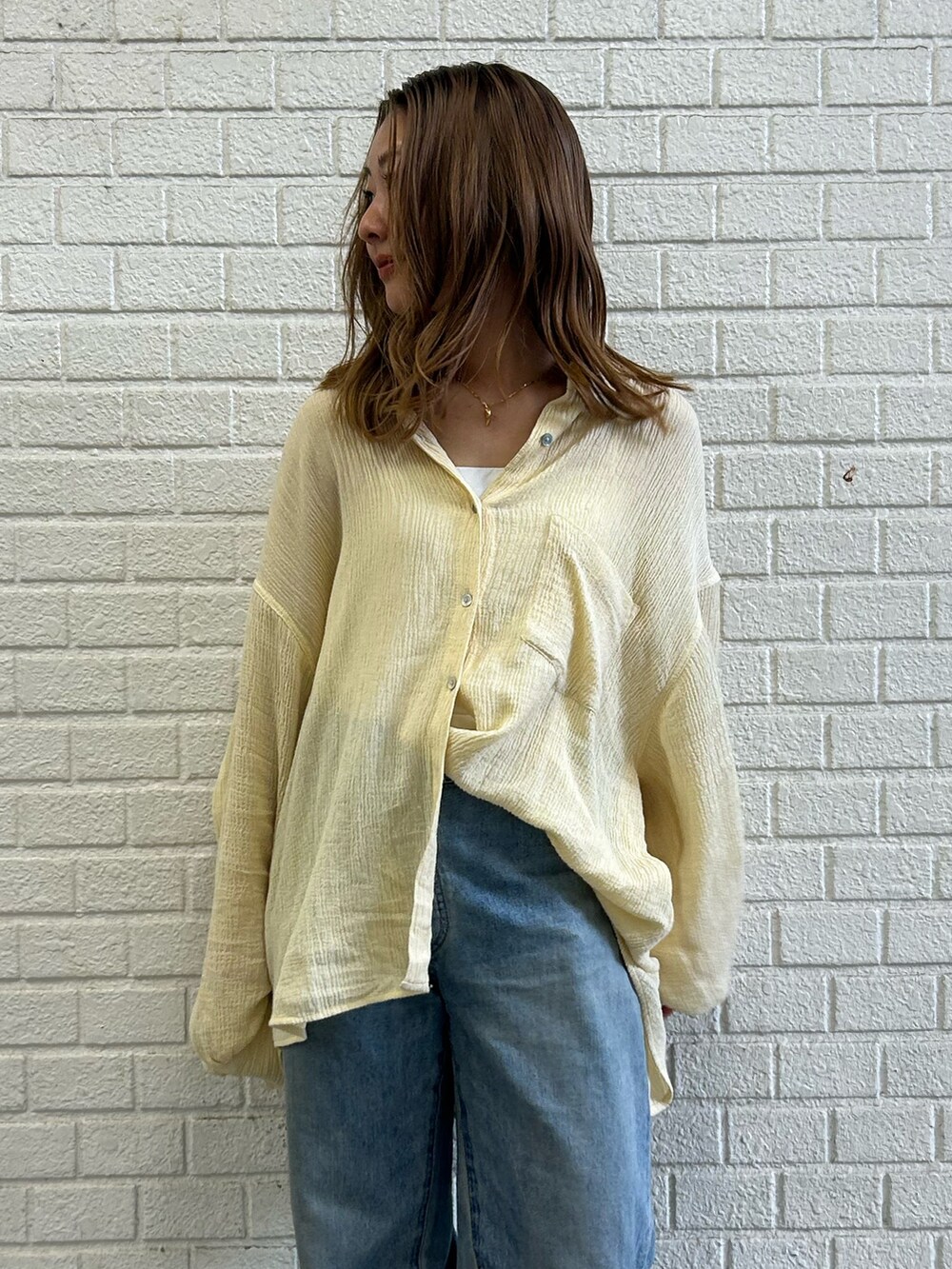 イエロー系のシャツ/ブラウス、ブルー系のデニムパンツを着用したレディースの春コーディネートの4枚目の写真