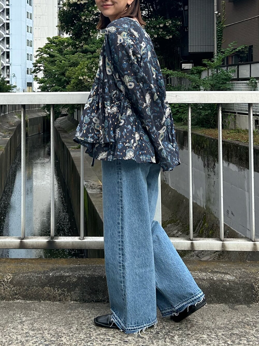 ブルー系のデニムパンツ、ブルー系のシャツ/ブラウス、ホワイト系のTシャツ/カットソーを着用したレディースの夏コーディネートの6枚目の写真