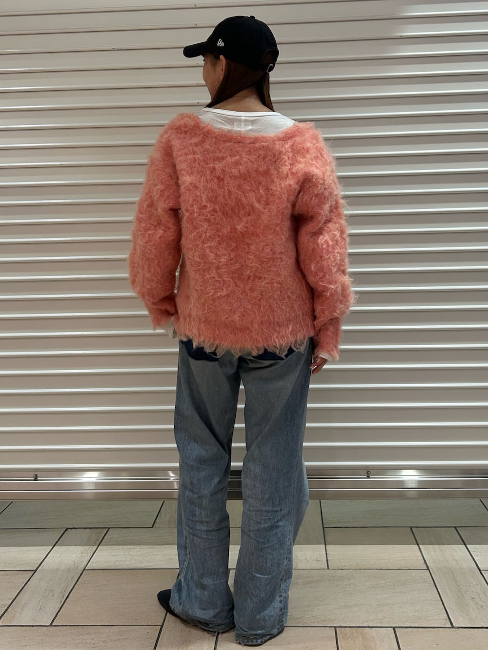 ピンク系のニット/セーター、ブルー系のデニムパンツを着用したレディースの冬コーディネートの3枚目の写真