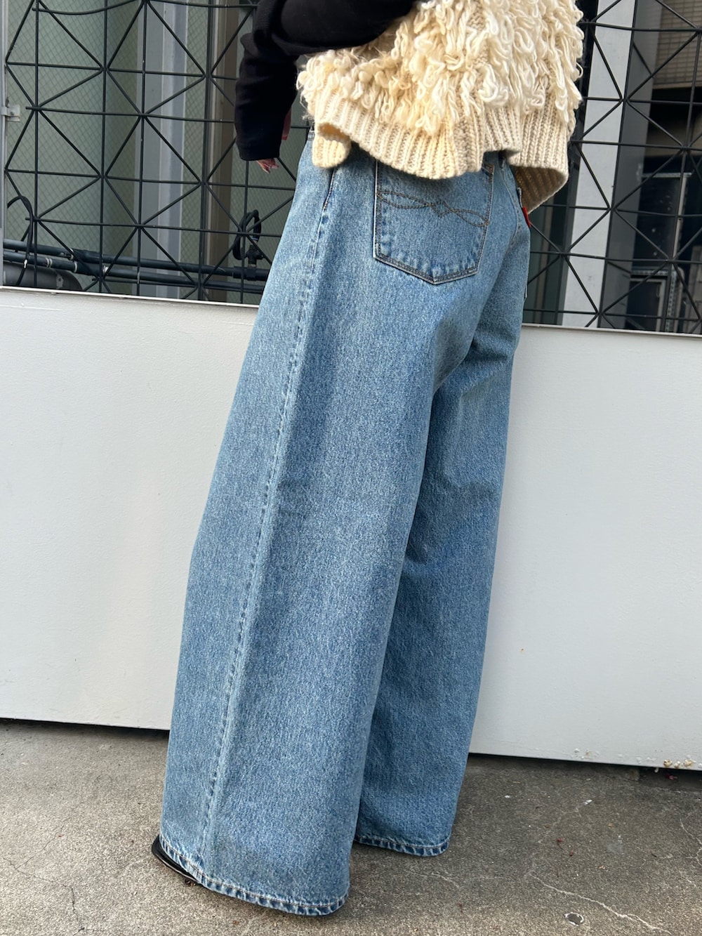 ホワイト系のベスト、ブラック系のTシャツ/カットソー、ブルー系のデニムパンツを着用したレディースの秋コーディネートの6枚目の写真