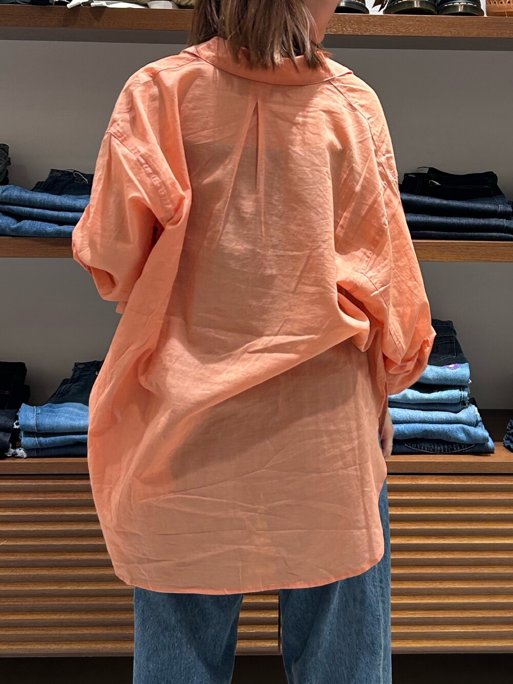 ブルー系のデニムパンツ、ブラック系のキャミソール、オレンジ系のシャツ/ブラウスを着用したレディースの春コーディネートの6枚目の写真