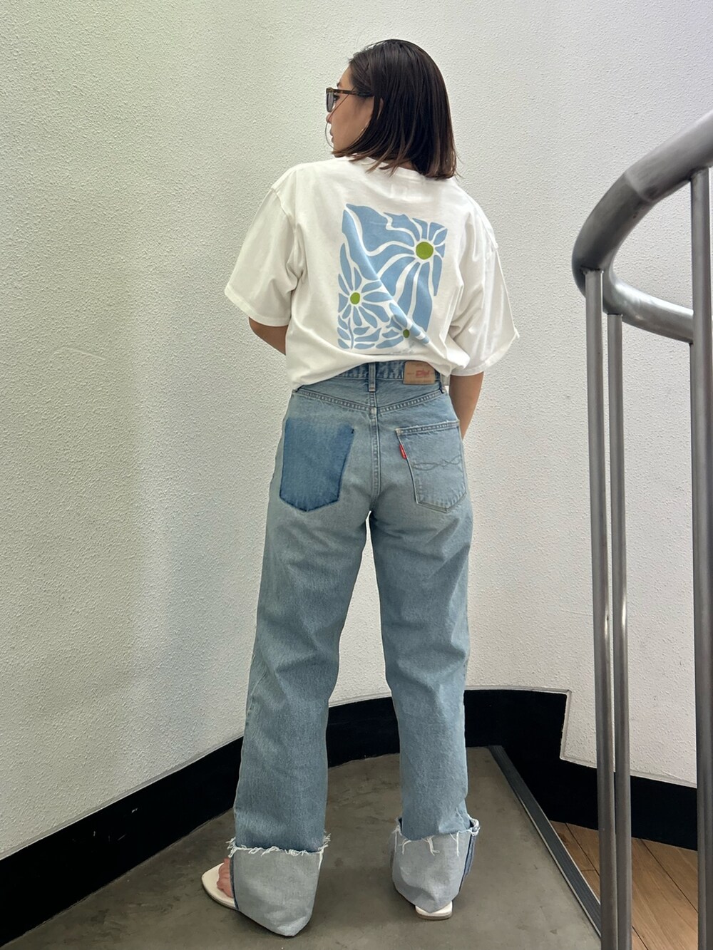 ホワイト系のTシャツ/カットソー、ブルー系のデニムパンツ、ホワイト系のサンダルを着用したレディースの夏コーディネートの3枚目の写真