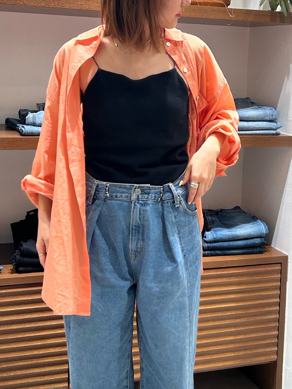 ブルー系のデニムパンツ、ブラック系のキャミソール、オレンジ系のシャツ/ブラウスを着用したレディースの春コーディネートの3枚目の写真