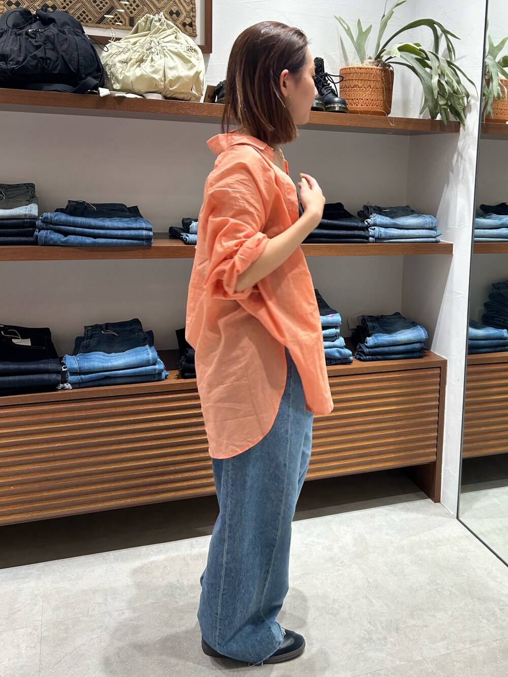 ブルー系のデニムパンツ、ブラック系のキャミソール、オレンジ系のシャツ/ブラウスを着用したレディースの春コーディネートの2枚目の写真