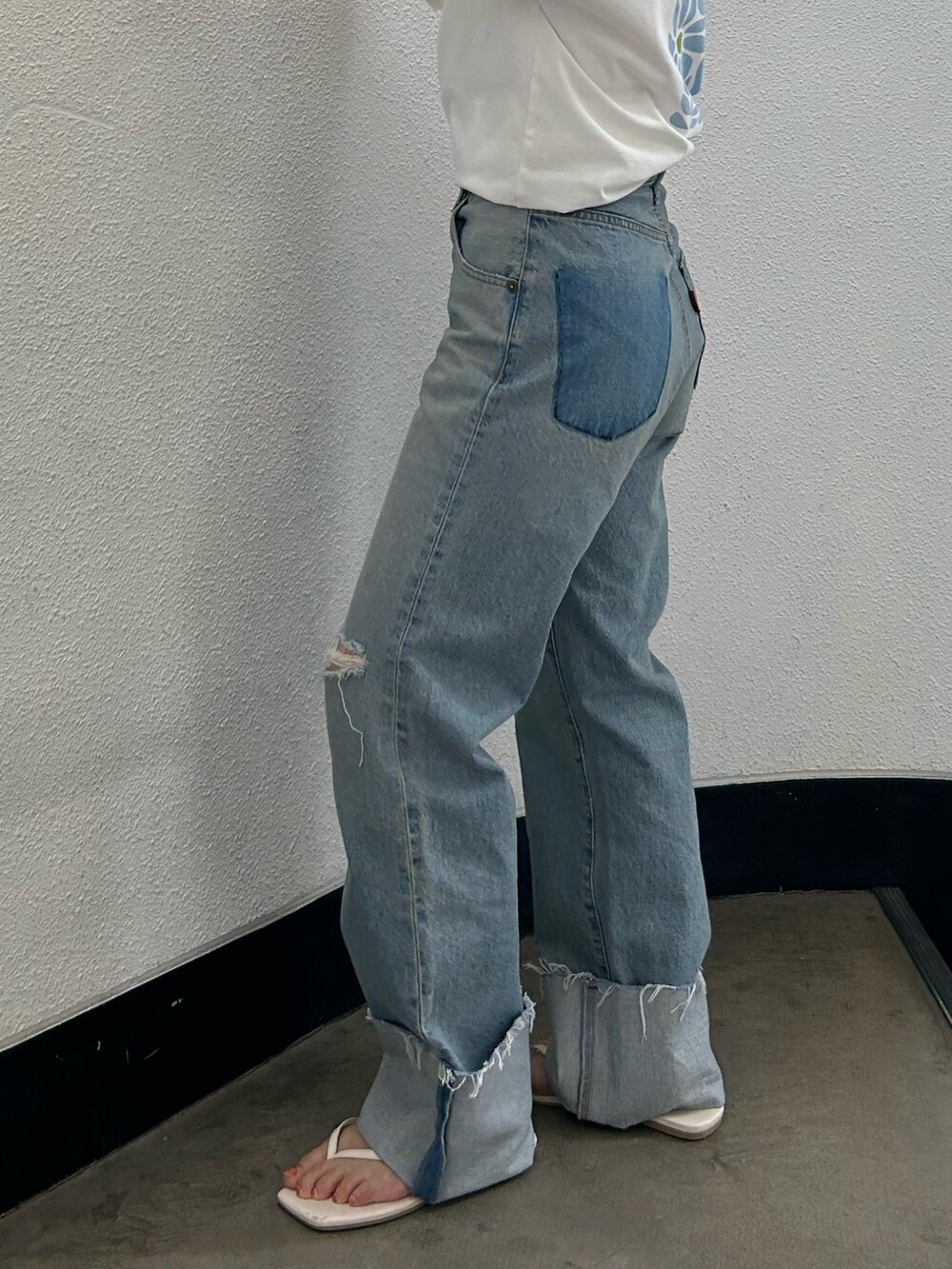 ホワイト系のTシャツ/カットソー、ブルー系のデニムパンツ、ホワイト系のサンダルを着用したレディースの夏コーディネートの7枚目の写真