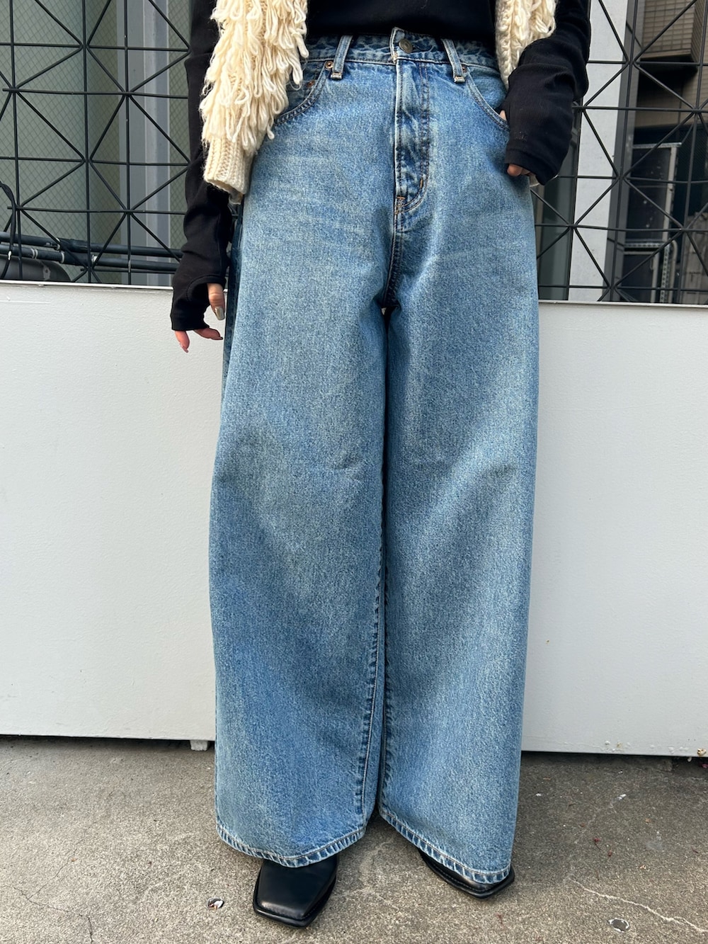 ホワイト系のベスト、ブラック系のTシャツ/カットソー、ブルー系のデニムパンツを着用したレディースの秋コーディネートの5枚目の写真