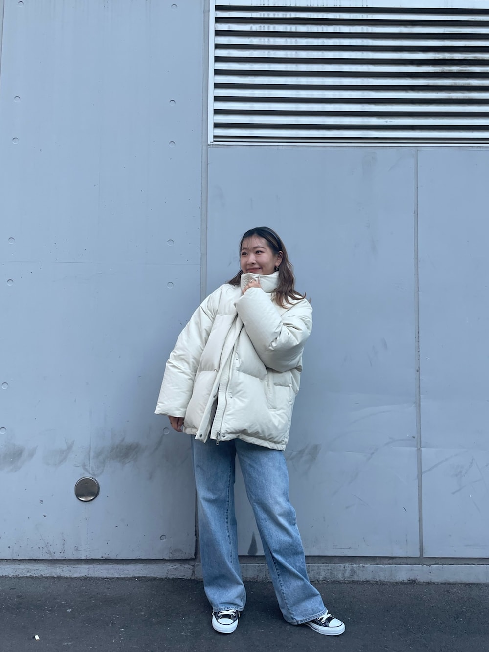 ホワイト系のダウンジャケット/コート、ブルー系のデニムパンツを着用したレディースの冬コーディネートの2枚目の写真