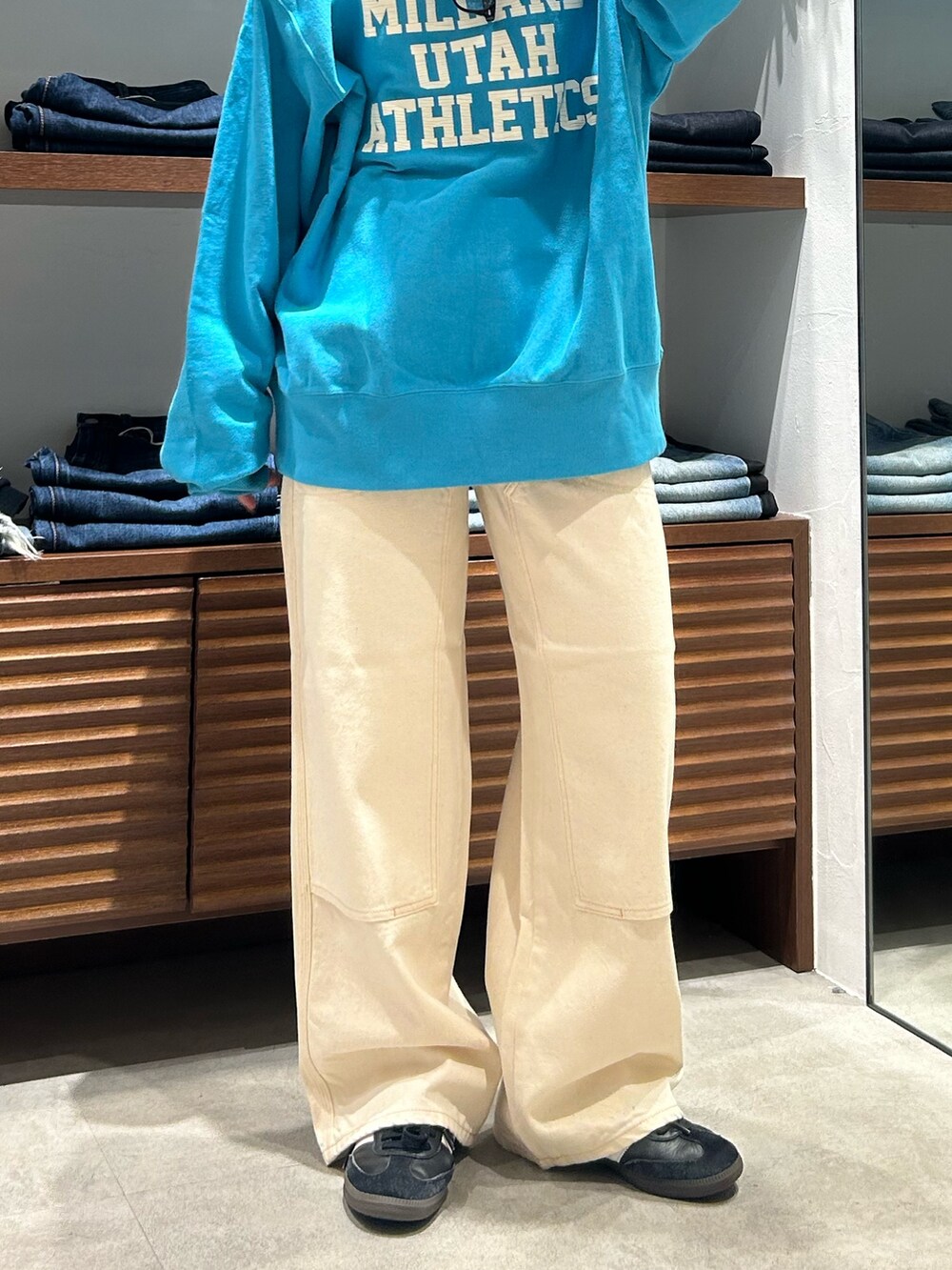 ブルー系のスウェット、ホワイト系のデニムパンツを着用したレディースの冬コーディネートの5枚目の写真