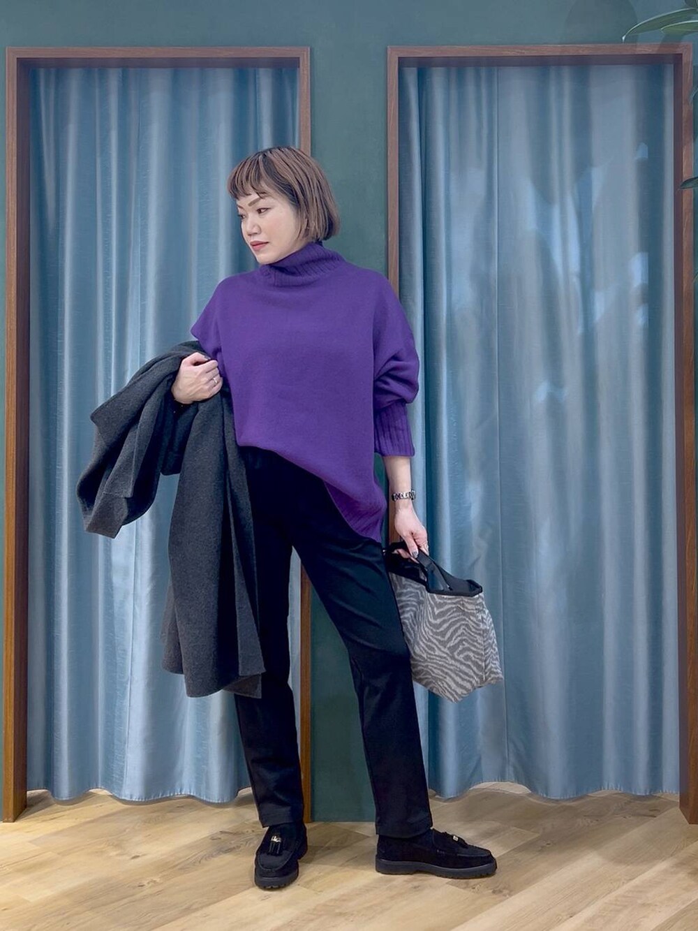 ブラック系のその他パンツ、パープル系のニット/セーター、グレー系のチェスターコートを着用したレディースの秋コーディネートの5枚目の写真