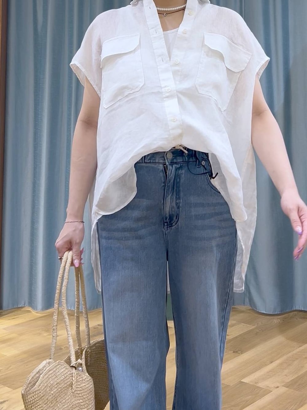 ブルー系のデニムパンツ、ホワイト系のタンクトップ、ブラック系のサンダルを着用したレディースの夏コーディネートの7枚目の写真