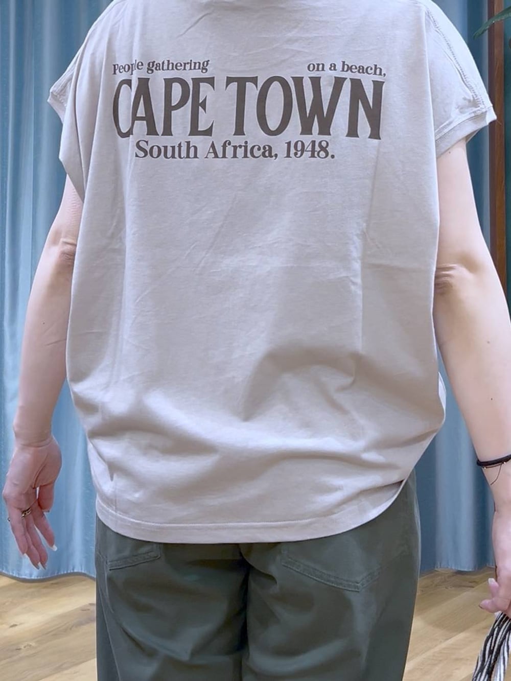 ブラック系のトートバッグ、ベージュ系のTシャツ/カットソー、グリーン系のチノパンツを着用したレディースの夏コーディネートの8枚目の写真