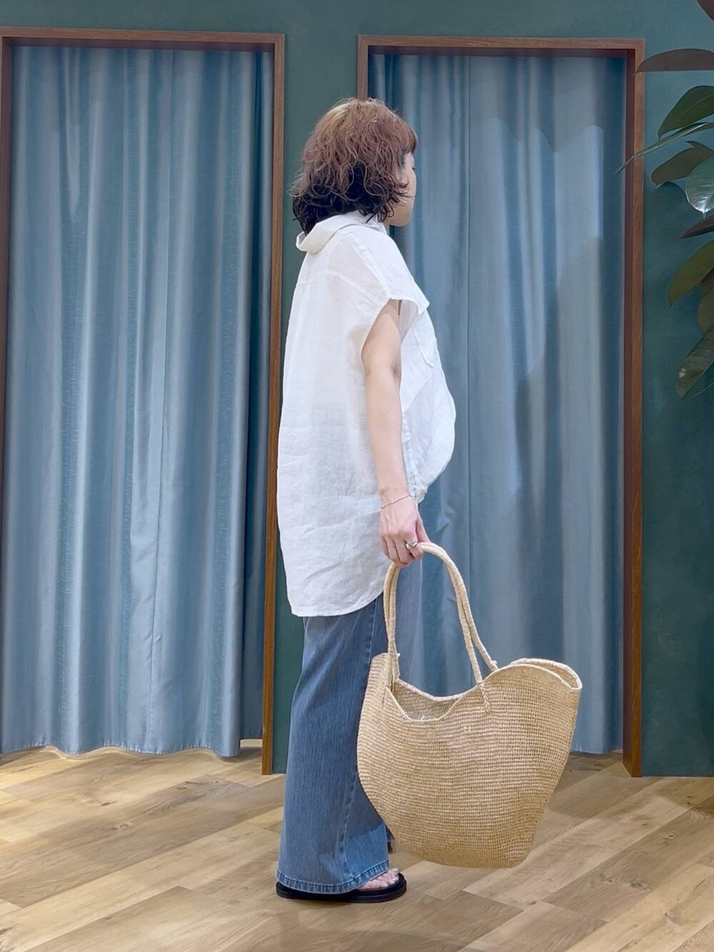 ブルー系のデニムパンツ、ホワイト系のタンクトップ、ブラック系のサンダルを着用したレディースの夏コーディネートの5枚目の写真