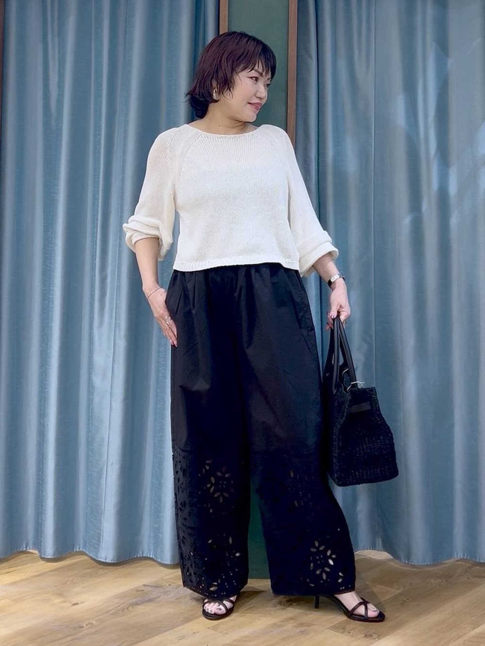 ホワイト系のニット/セーター、ブラック系のその他パンツ、ブラック系のサンダルを着用したレディースの春コーディネートの2枚目の写真