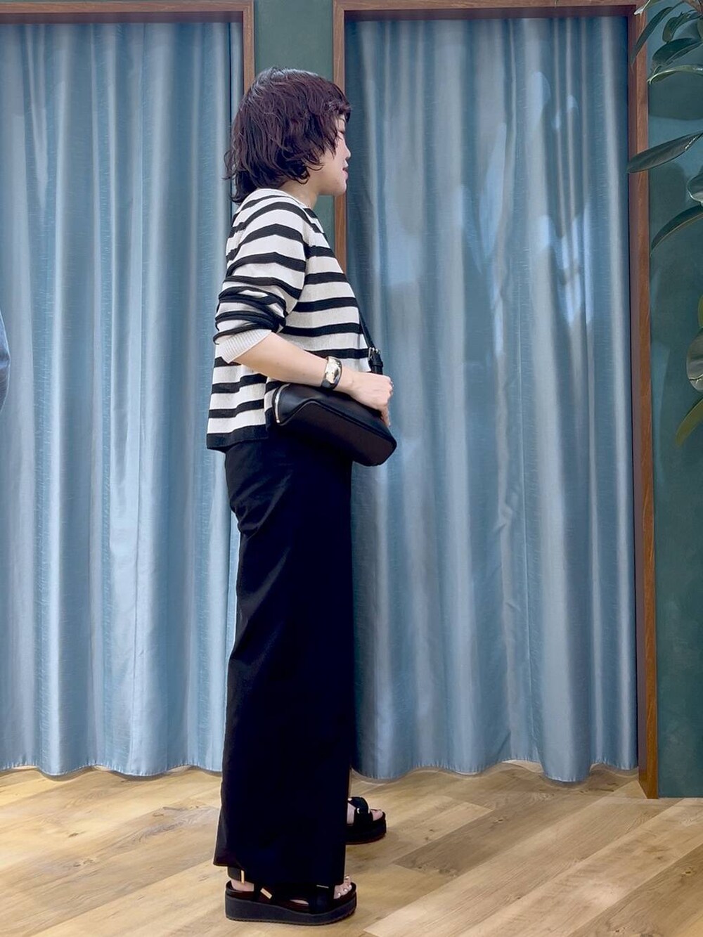 ベージュ系のニット/セーター、ブラック系のその他パンツ、ブラック系のショルダーバッグを着用したレディースの春コーディネートの4枚目の写真