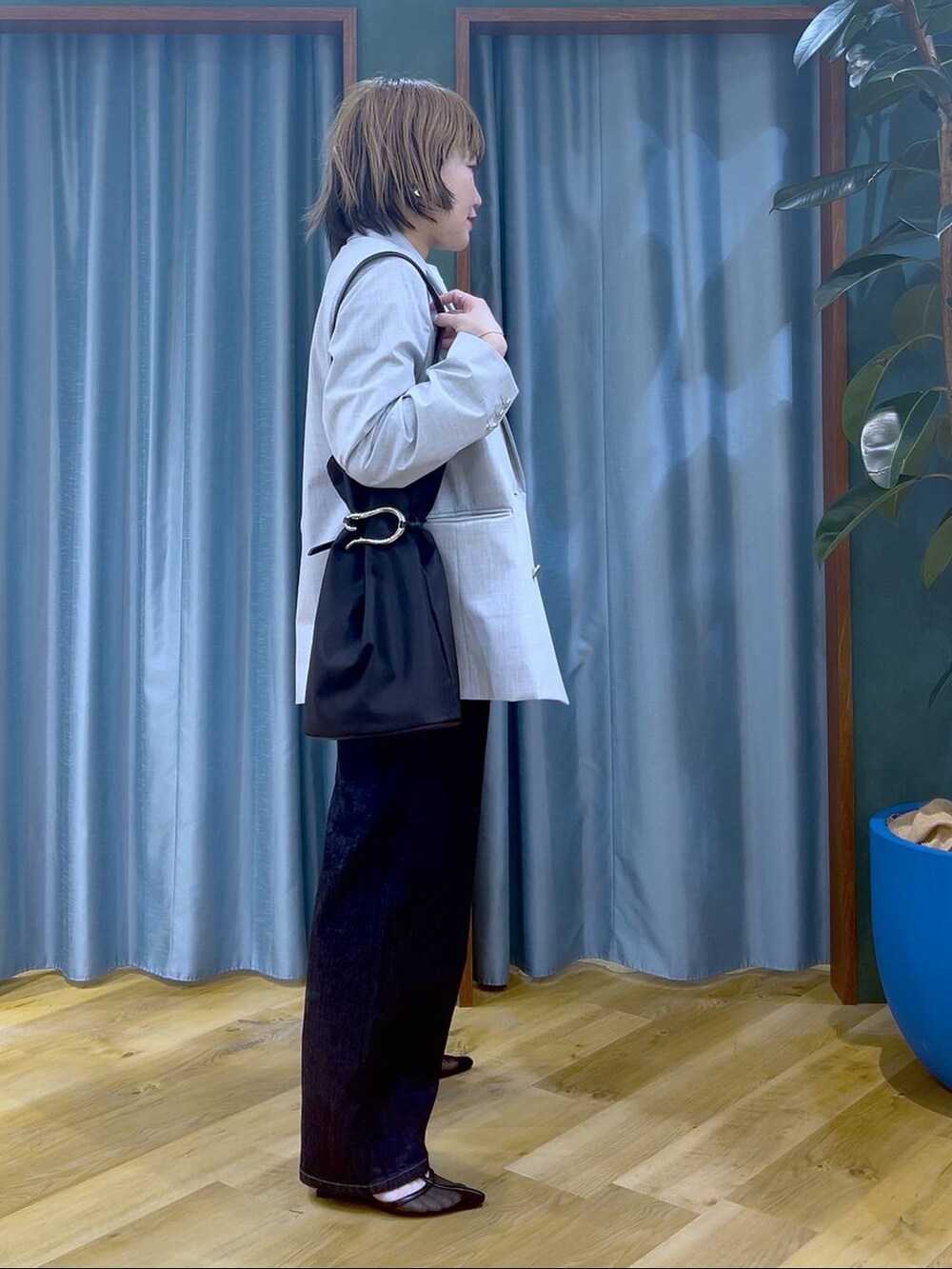 ブルー系のデニムパンツ、グレー系のテーラードジャケット、ホワイト系のTシャツ/カットソーを着用したレディースの冬コーディネートの5枚目の写真