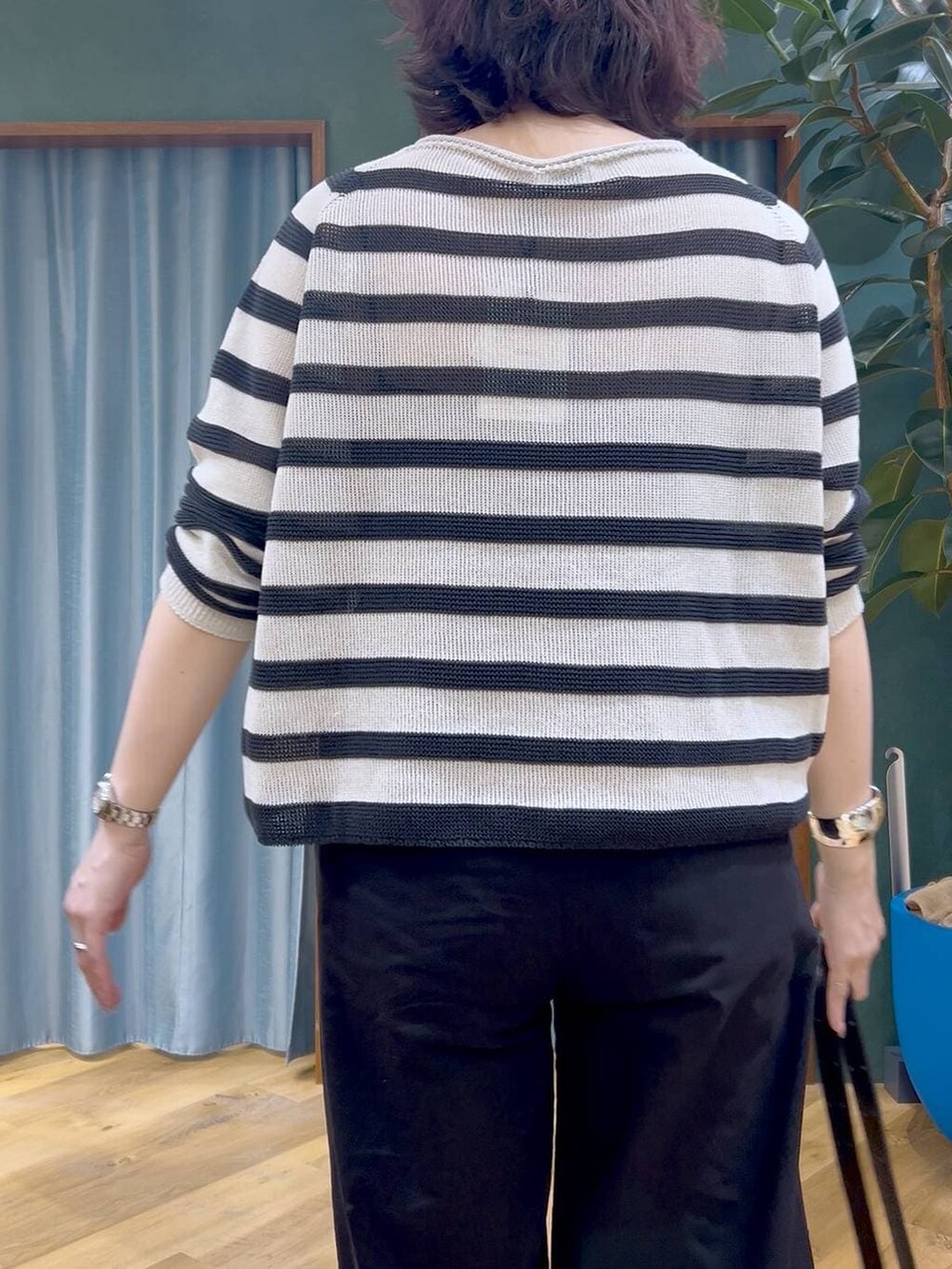 ベージュ系のニット/セーター、ブラック系のその他パンツ、ブラック系のショルダーバッグを着用したレディースの春コーディネートの7枚目の写真