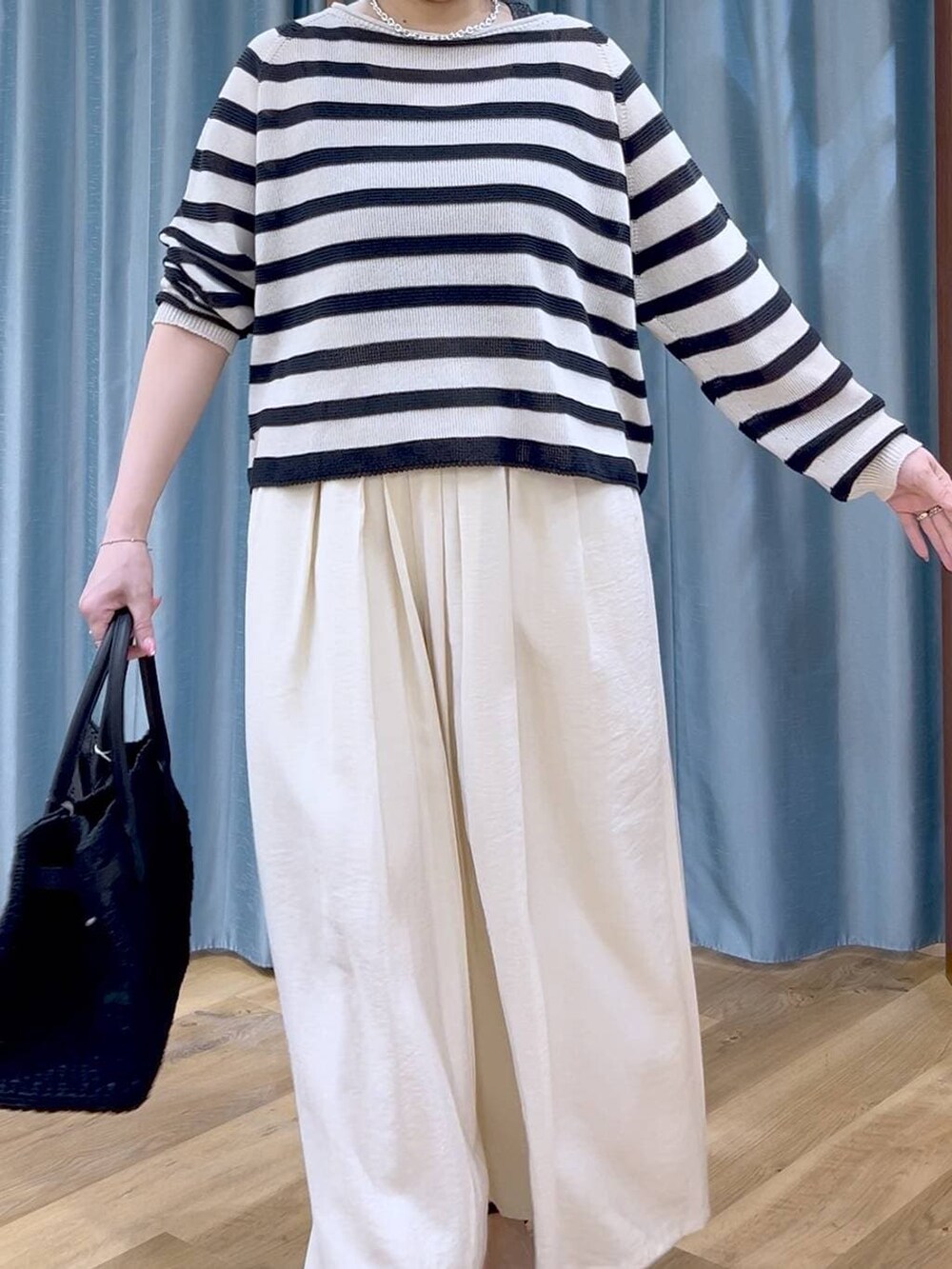 ベージュ系のニット/セーター、ホワイト系のその他パンツ、ブラック系のサンダルを着用したレディースの春コーディネートの5枚目の写真