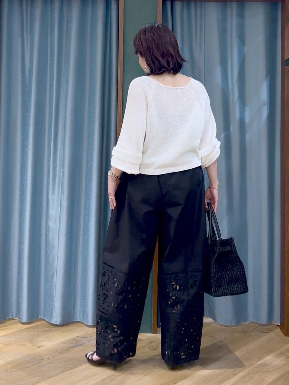 ホワイト系のニット/セーター、ブラック系のその他パンツ、ブラック系のサンダルを着用したレディースの春コーディネートの5枚目の写真