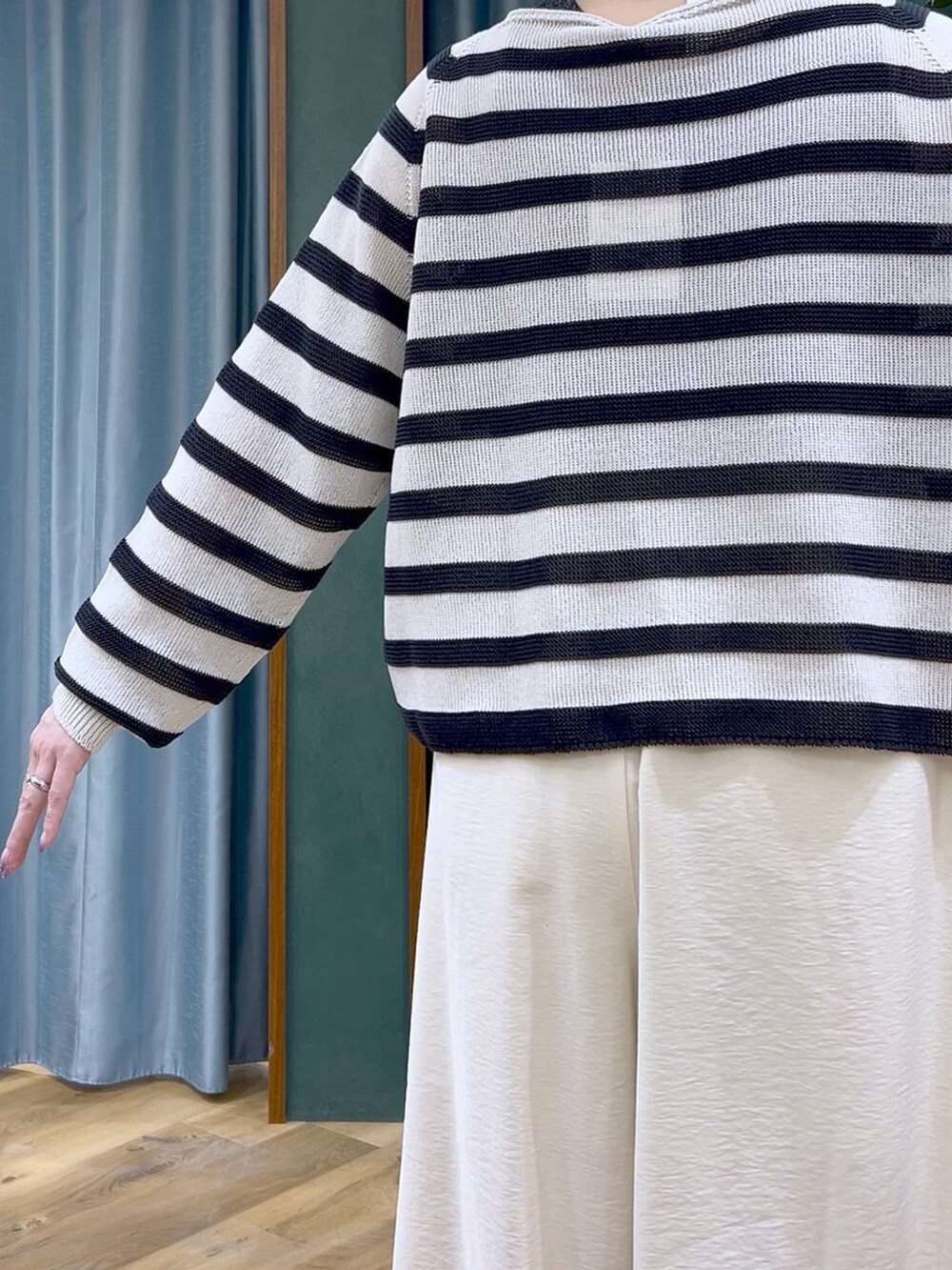 ベージュ系のニット/セーター、ホワイト系のその他パンツ、ブラック系のサンダルを着用したレディースの春コーディネートの6枚目の写真