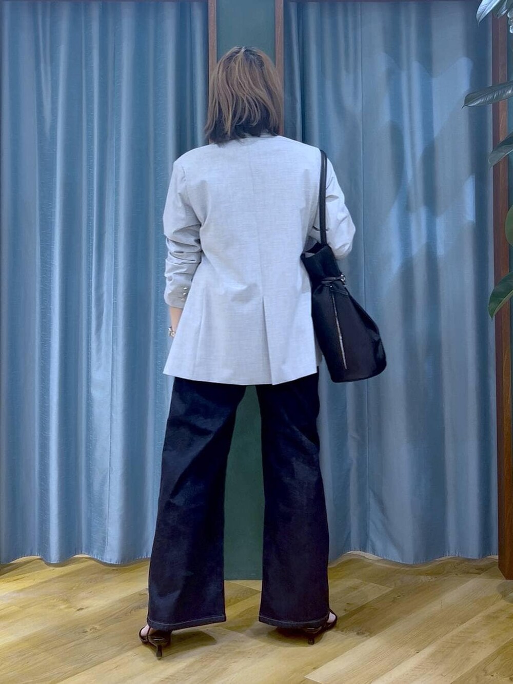 ブルー系のデニムパンツ、グレー系のテーラードジャケット、ホワイト系のTシャツ/カットソーを着用したレディースの冬コーディネートの6枚目の写真