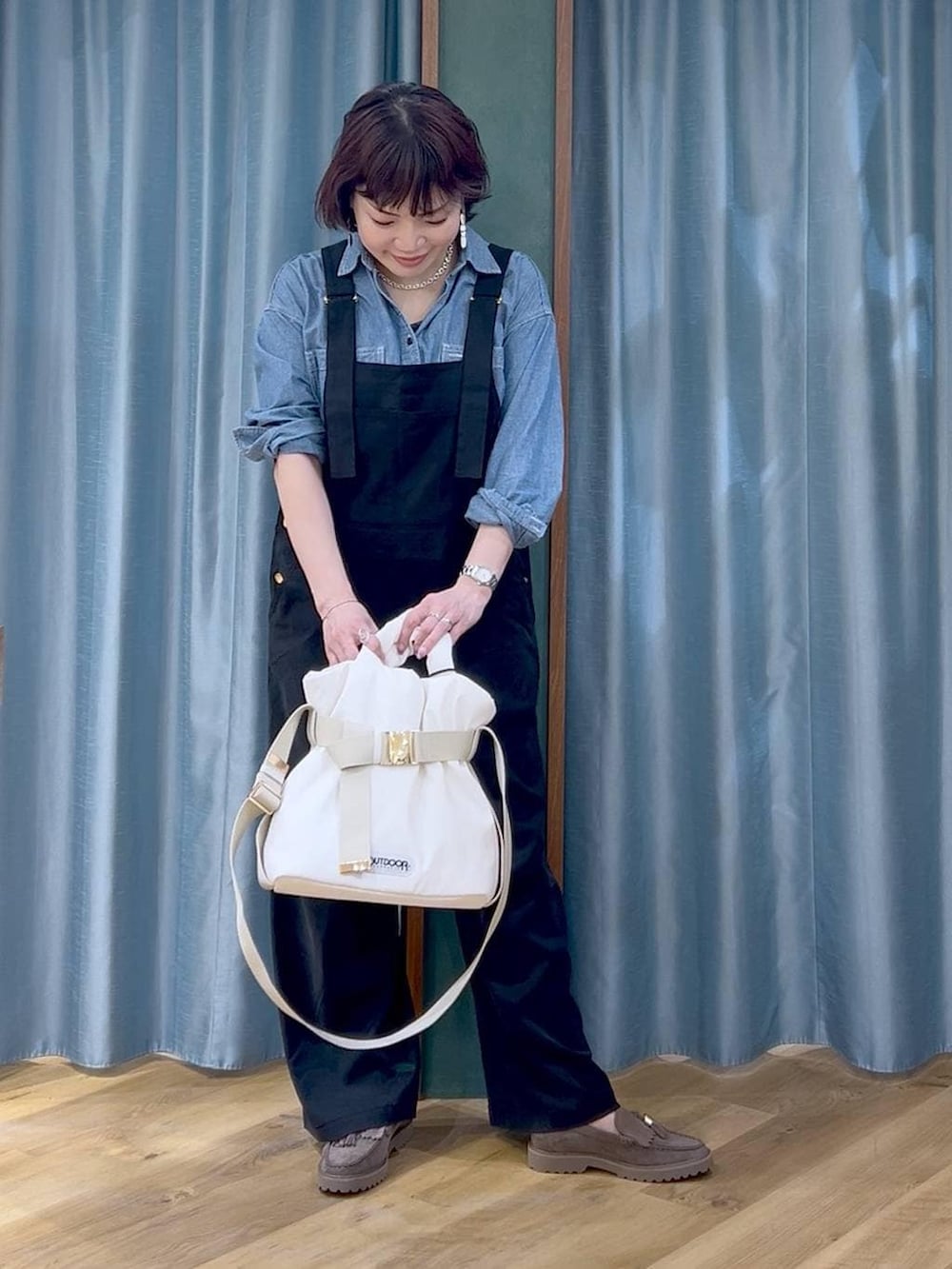 グレー系のローファー、ブラック系のサロペット/オーバーオール、ホワイト系のトートバッグを着用したレディースの春コーディネートの4枚目の写真