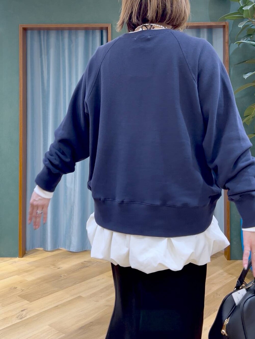 ブラック系のボストンバッグ、ブラック系のスカート、ホワイト系のTシャツ/カットソーを着用したレディースの秋コーディネートの6枚目の写真