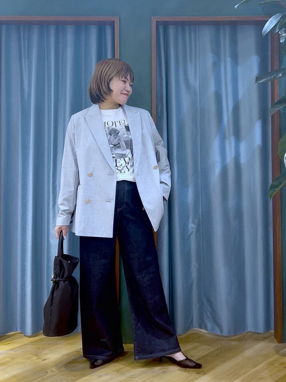 ブルー系のデニムパンツ、グレー系のテーラードジャケット、ホワイト系のTシャツ/カットソーを着用したレディースの冬コーディネートの3枚目の写真