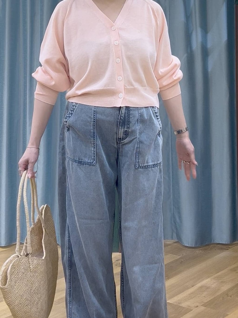 ブルー系のデニムパンツ、ピンク系のカーディガン/ボレロ、ベージュ系のかごバッグを着用したレディースの春コーディネートの5枚目の写真