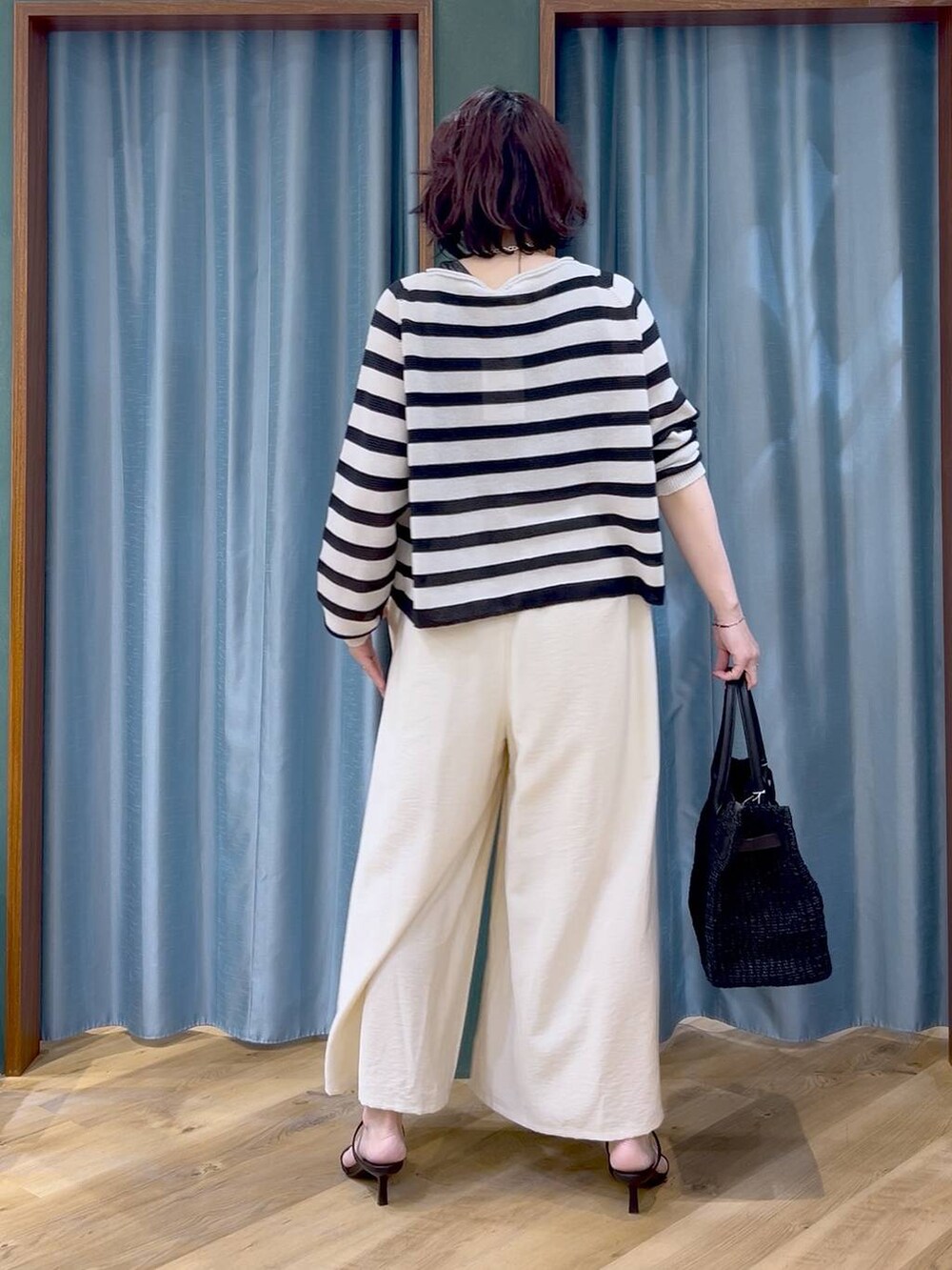 ベージュ系のニット/セーター、ホワイト系のその他パンツ、ブラック系のサンダルを着用したレディースの春コーディネートの4枚目の写真