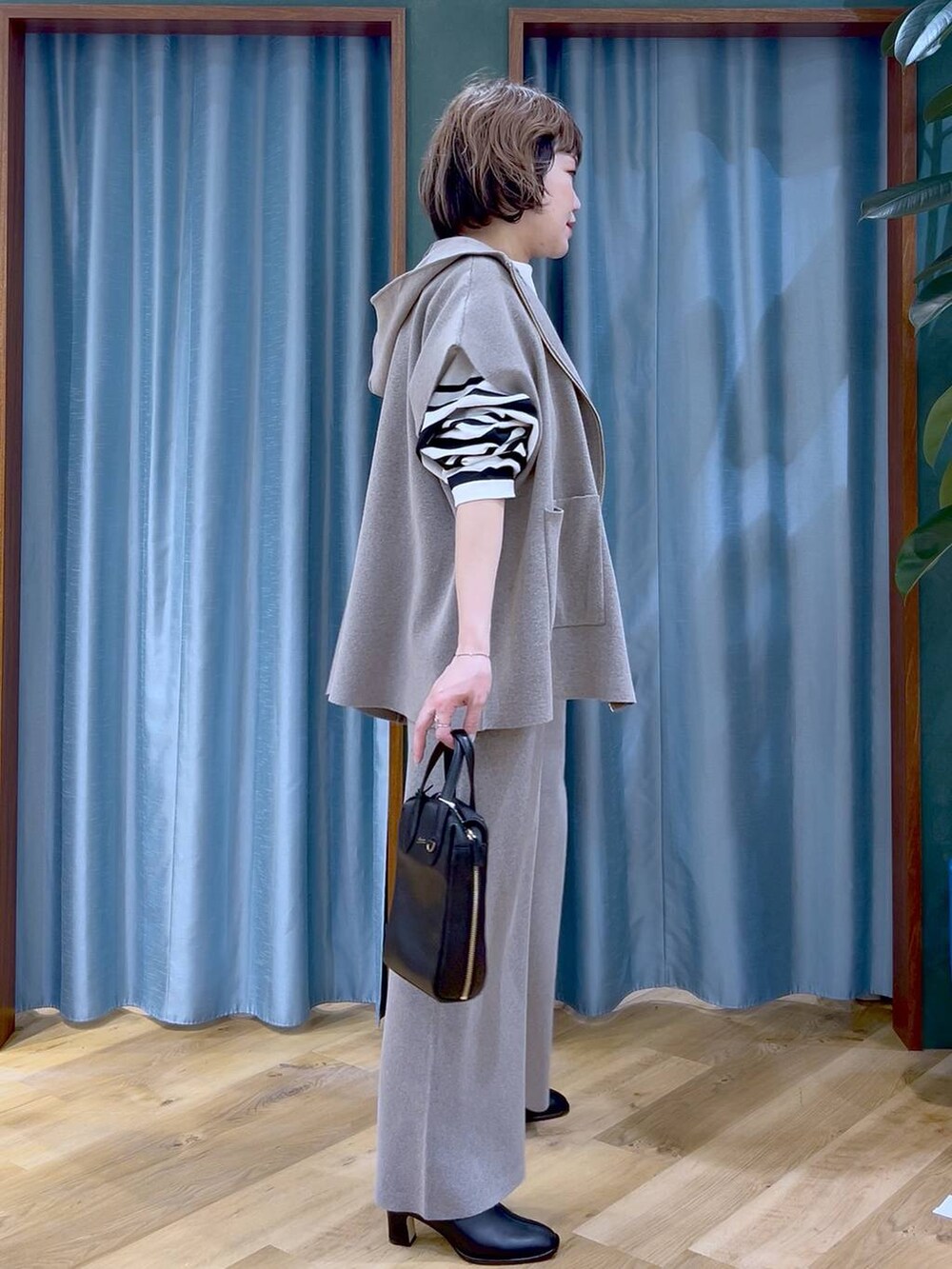 グレー系のベスト、グレー系のその他パンツ、ブラック系のブーツを着用したレディースの冬コーディネートの5枚目の写真