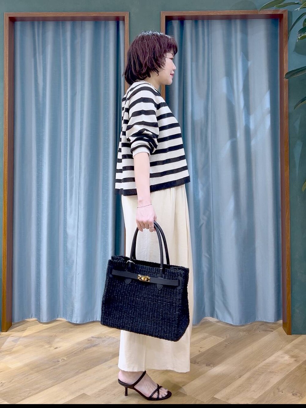 ベージュ系のニット/セーター、ホワイト系のその他パンツ、ブラック系のサンダルを着用したレディースの春コーディネートの3枚目の写真