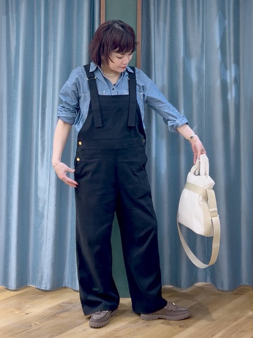 グレー系のローファー、ブラック系のサロペット/オーバーオール、ホワイト系のトートバッグを着用したレディースの春コーディネートの3枚目の写真