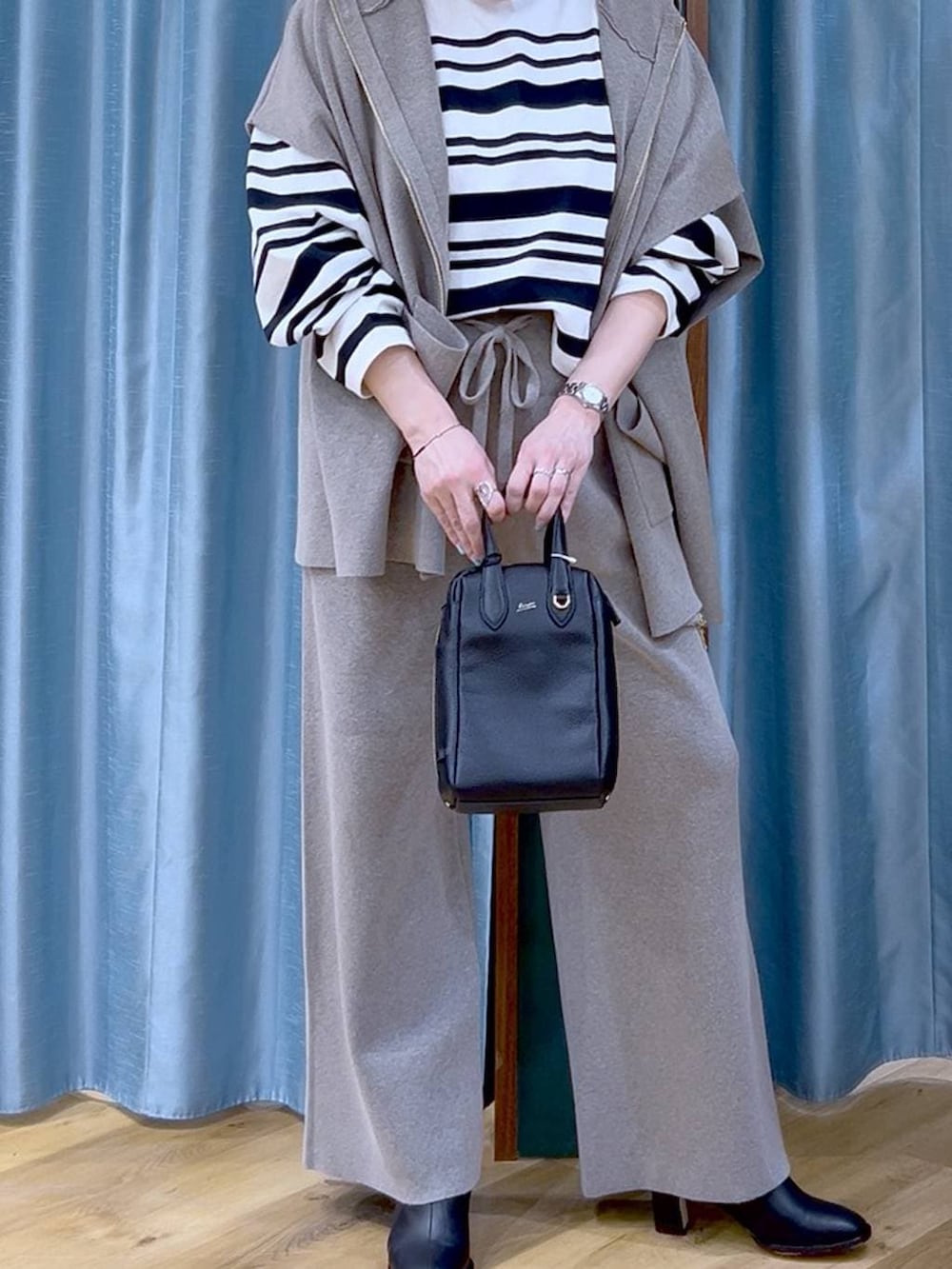 グレー系のベスト、グレー系のその他パンツ、ブラック系のブーツを着用したレディースの冬コーディネートの7枚目の写真